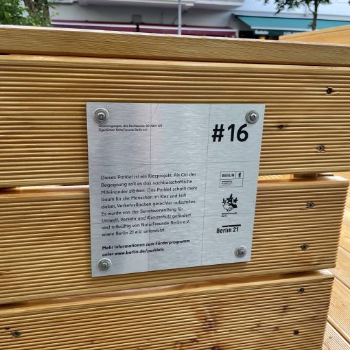 Schild am Parklet erklärt, wer das Projekt fördert und warum