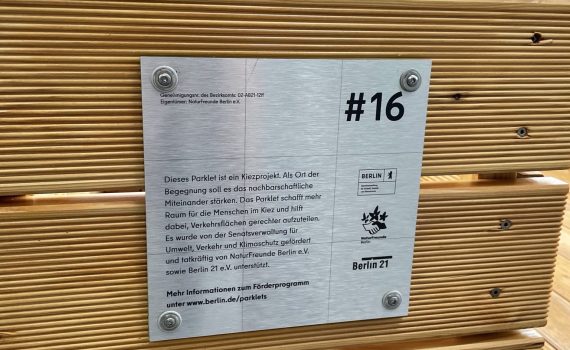 Schild am Parklet erklärt, wer das Projekt fördert und warum